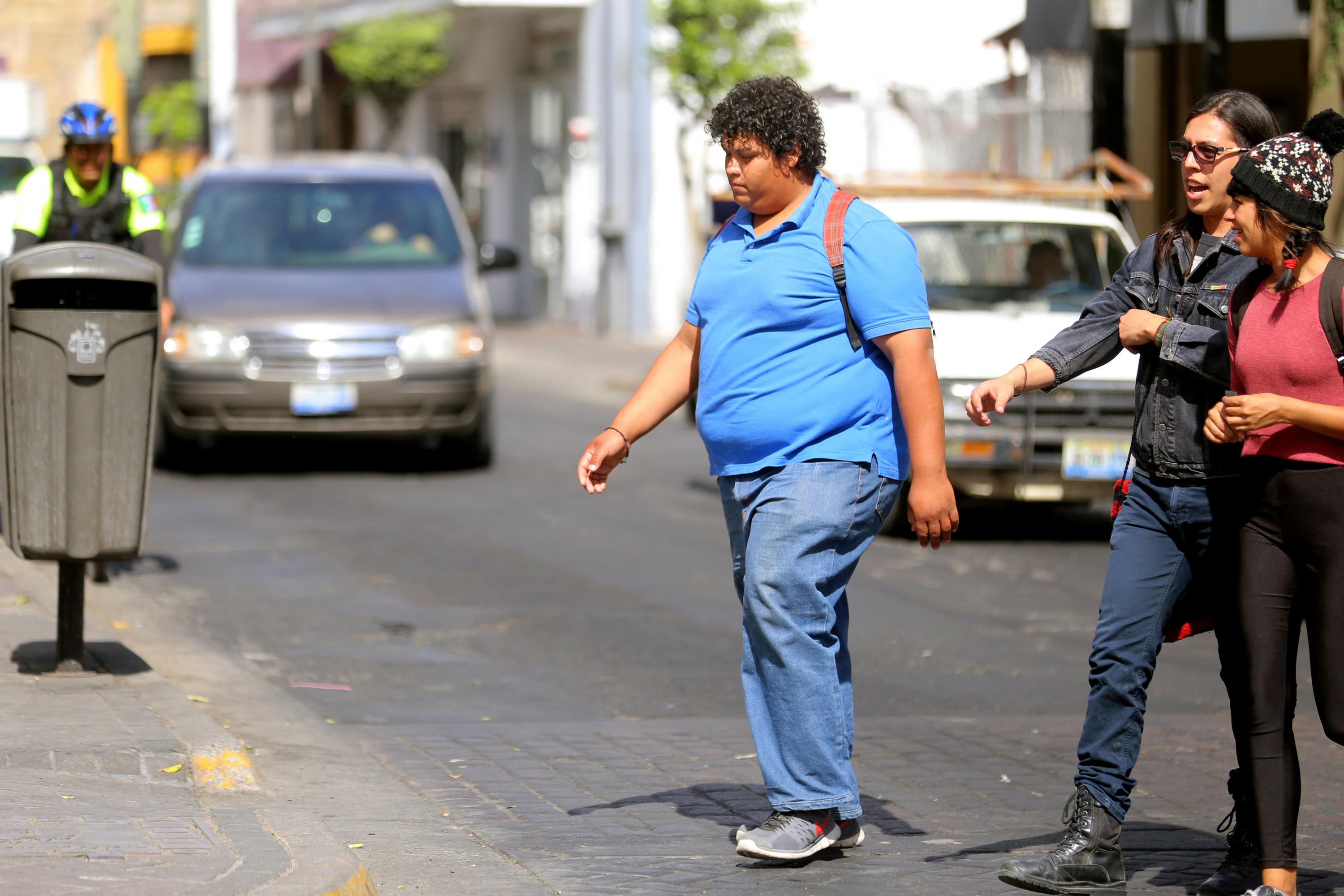 Persona obesa cruzando la calle