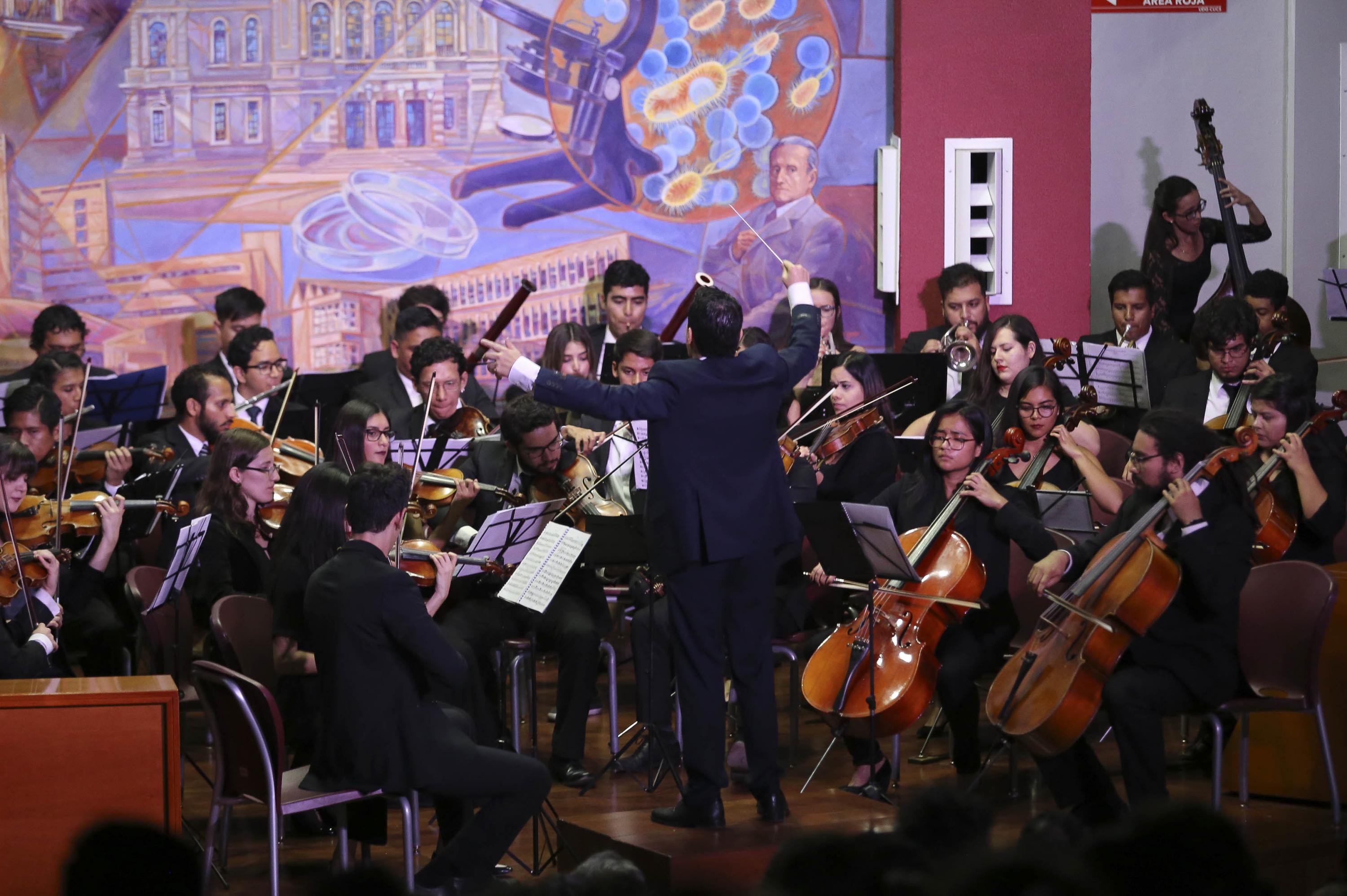Director tomado de espaldas dirigiendo la orquesta