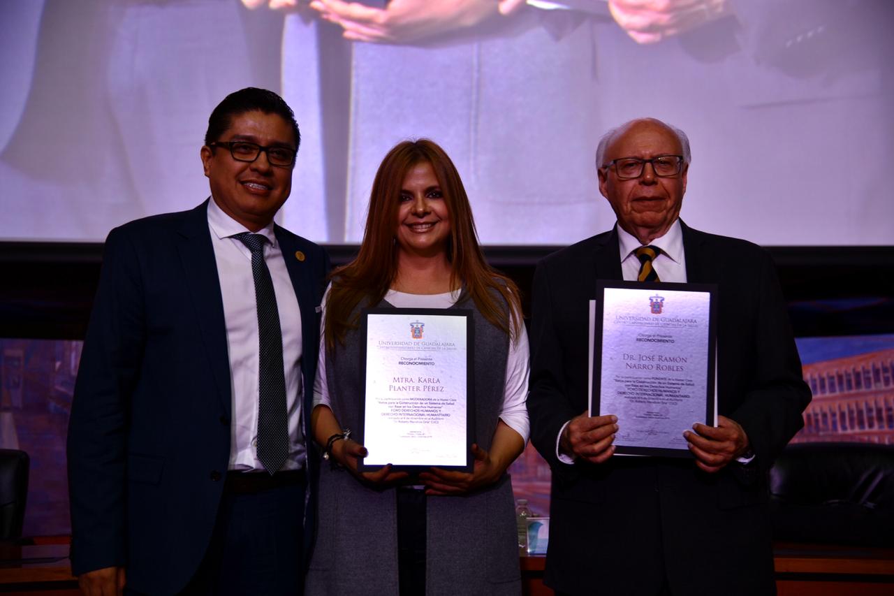 Participantes en el presídium exhibiendo reconocimiento