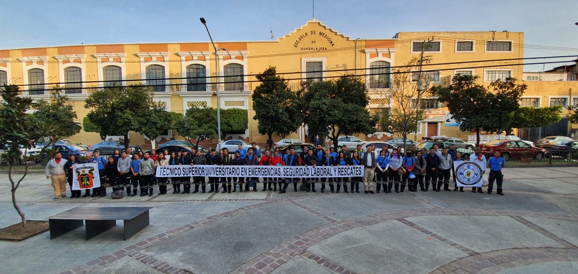 Grupo de alumnos de Emergencias posan para la foto, atrás la presidencia municipal de Aclatlán