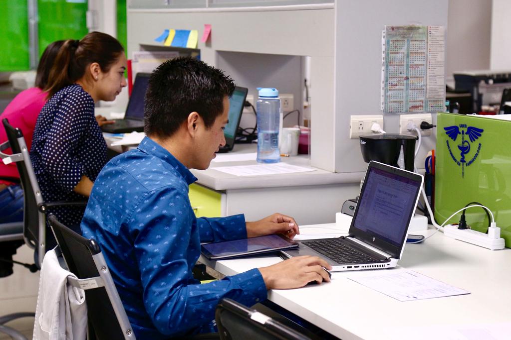 Alumnos del CUCS frente a una laptop