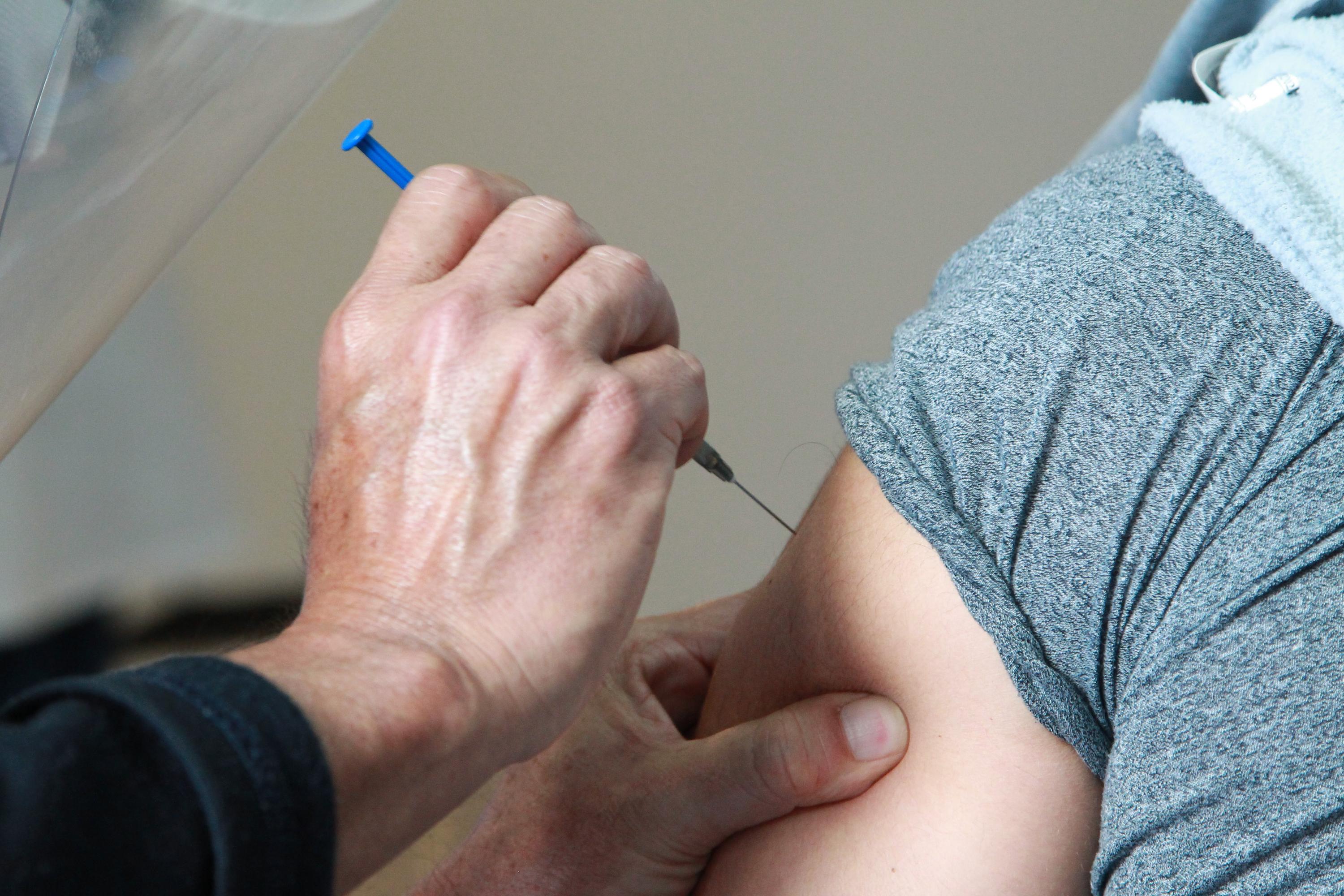 Momento de la aplicación de una vacuna en el brazo