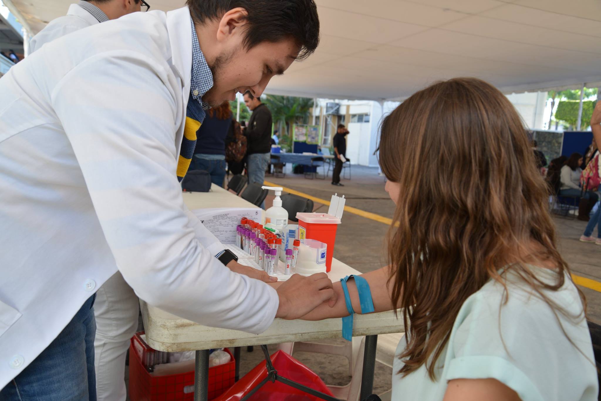 Médico extrayendo una muestra de sangre del brazo de una alumna del CUCS