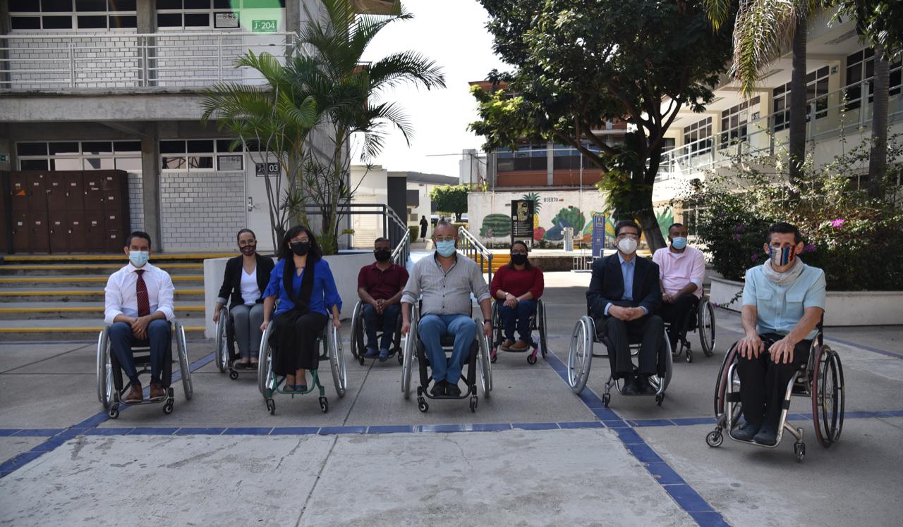 Académicos de CUCS sentados en silla de ruedas posando para la foto