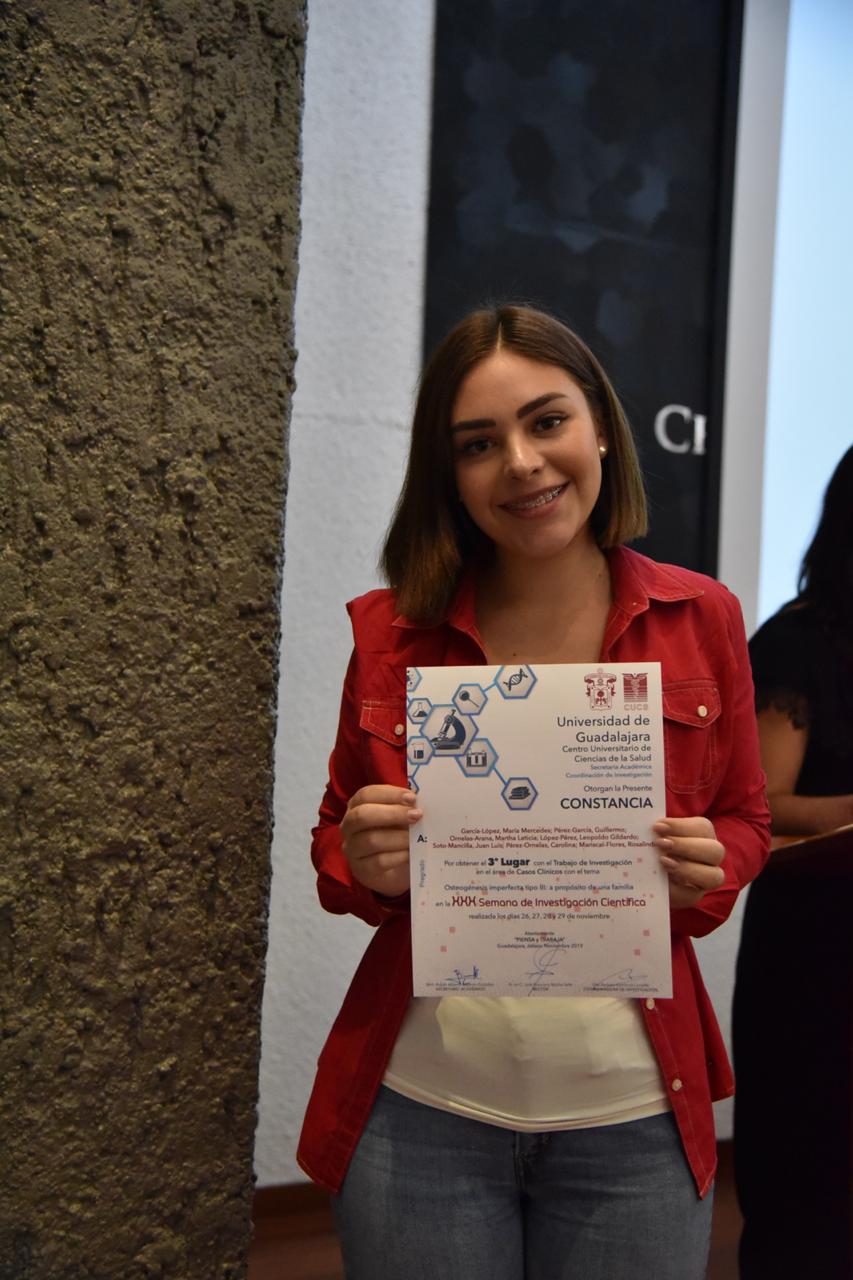 Alumna ganadora exhibiendo su reconocimiento