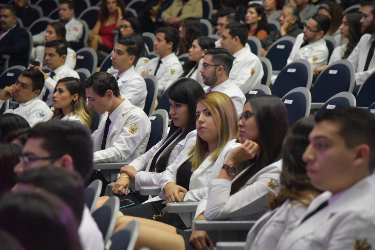 toma cerrada de alumnos graduados con su bata blanca