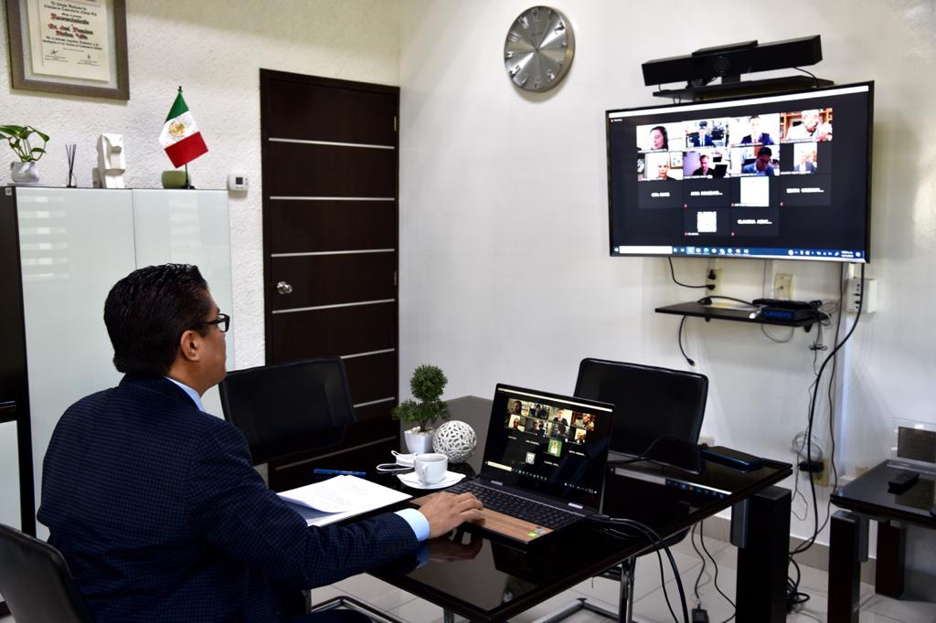 Rector de espalda, de frente pantalla donde se visualizan los participantes en la plataforma