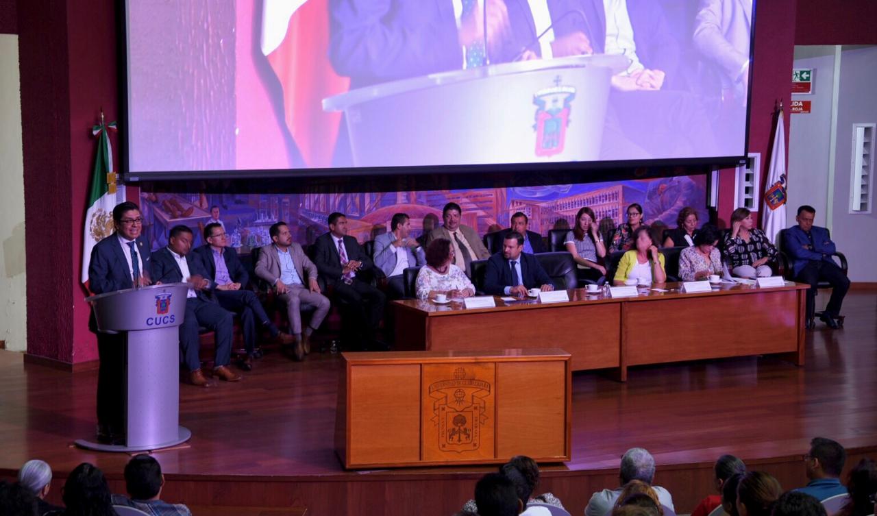 Rector CUCS ofreciendo mensaje en pódium, al fondo miembros del presídium