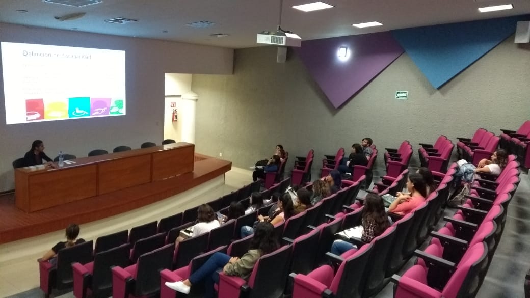 Toma general del auditorio tomada desde arriba, al fondo y abajo la jefa de la Unidad de Inclusión