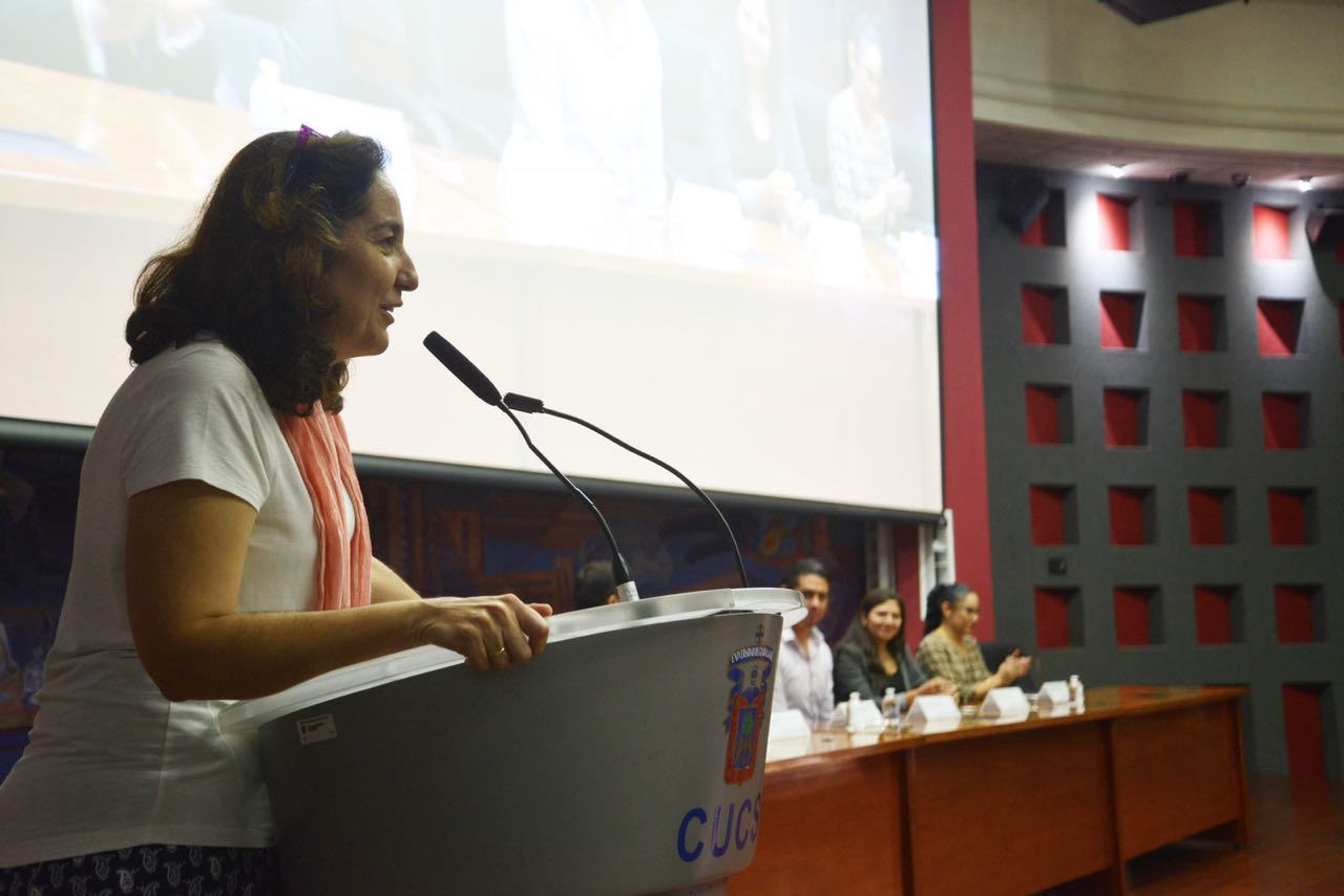 Dra. Barbara Vizmanos al micrófono en el podio