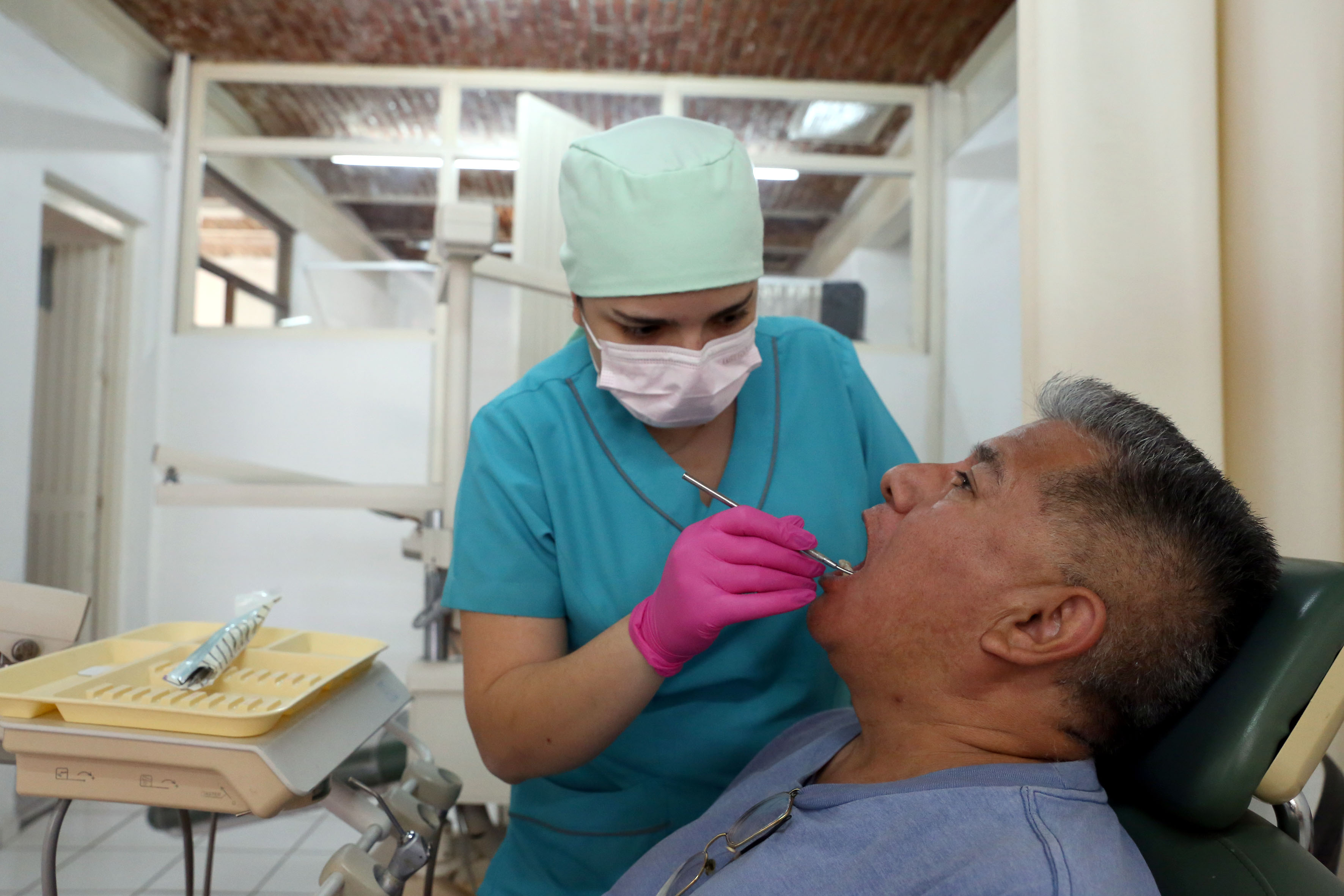 Pasante de Odontología atendiendo a un paciente