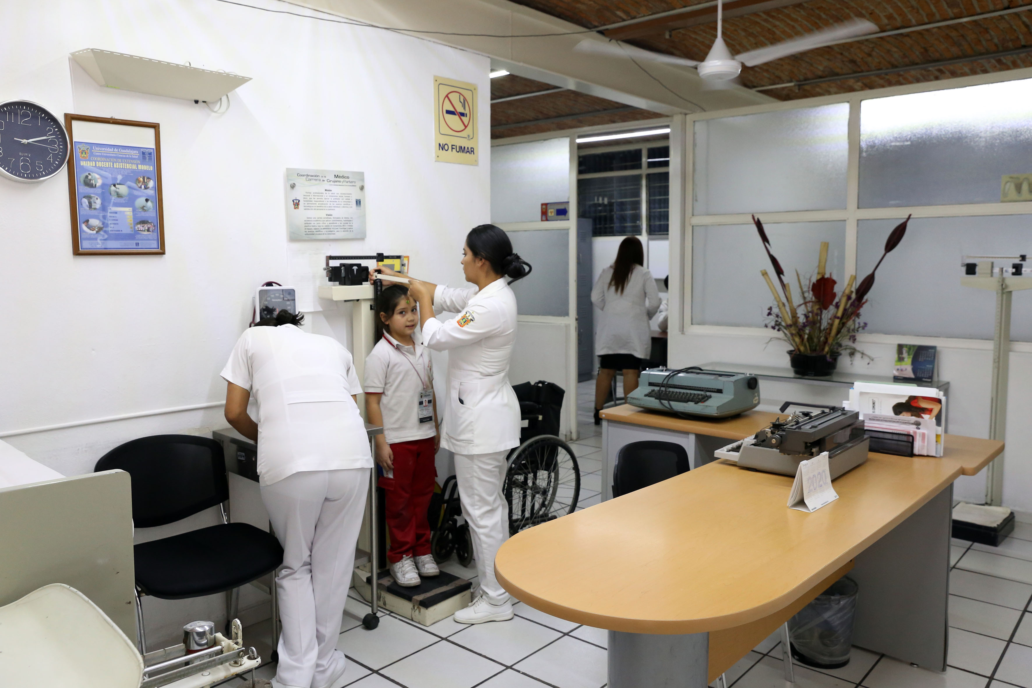 Enfermeras pesando y midiendo a una niña