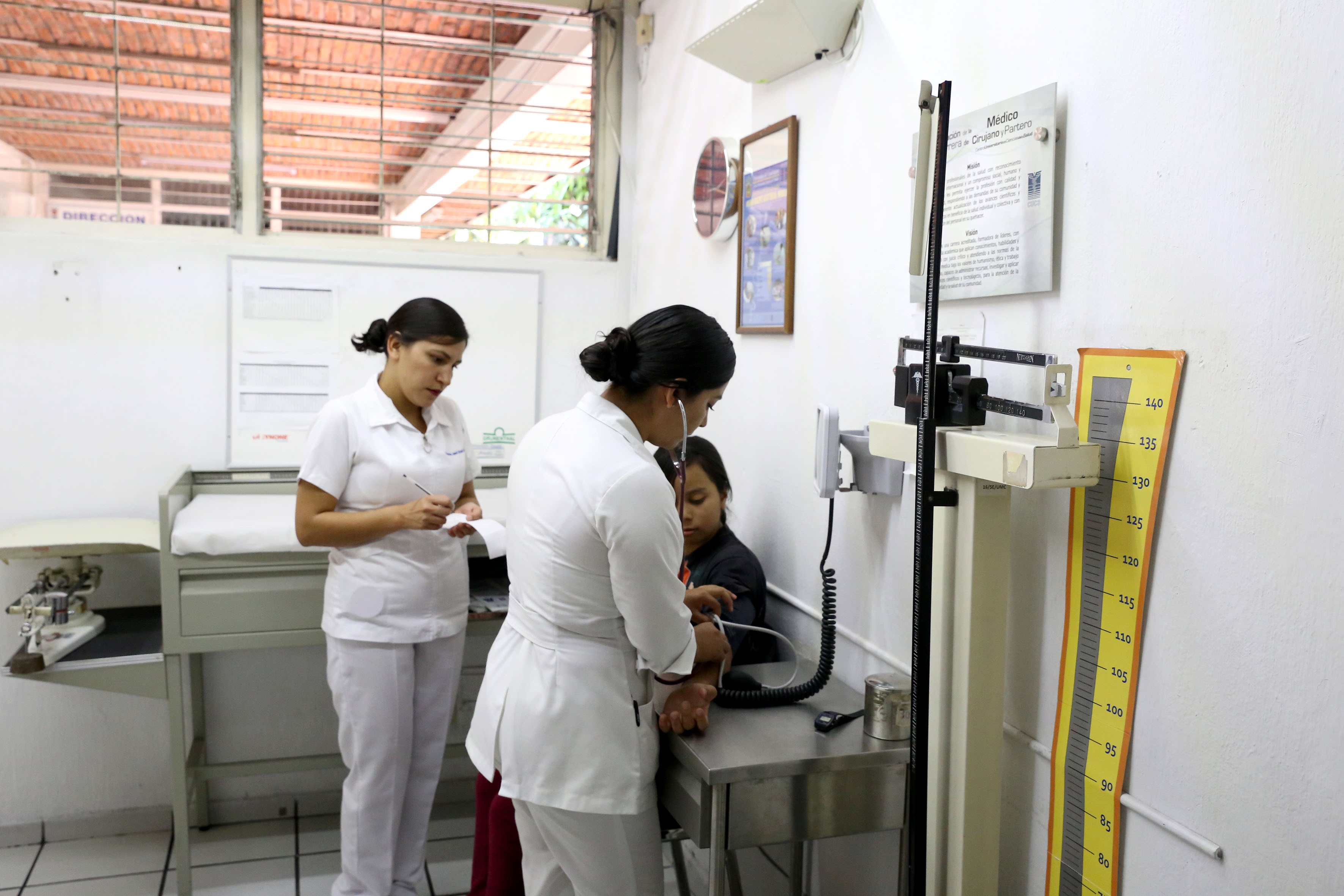 Enfermeras tomando la presión a un paciente adulto