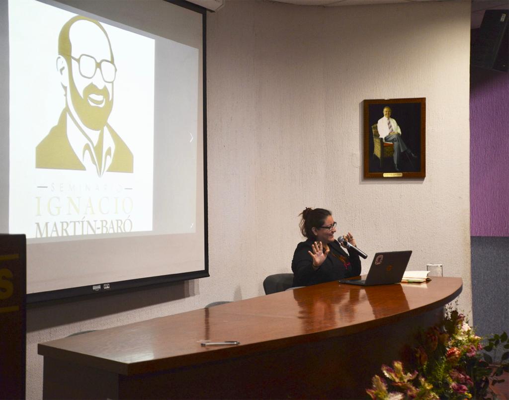 Ponente del Seminario Martín Baró dando conferencia, en la pantalla la imagen de Ignacio Martín Baró
