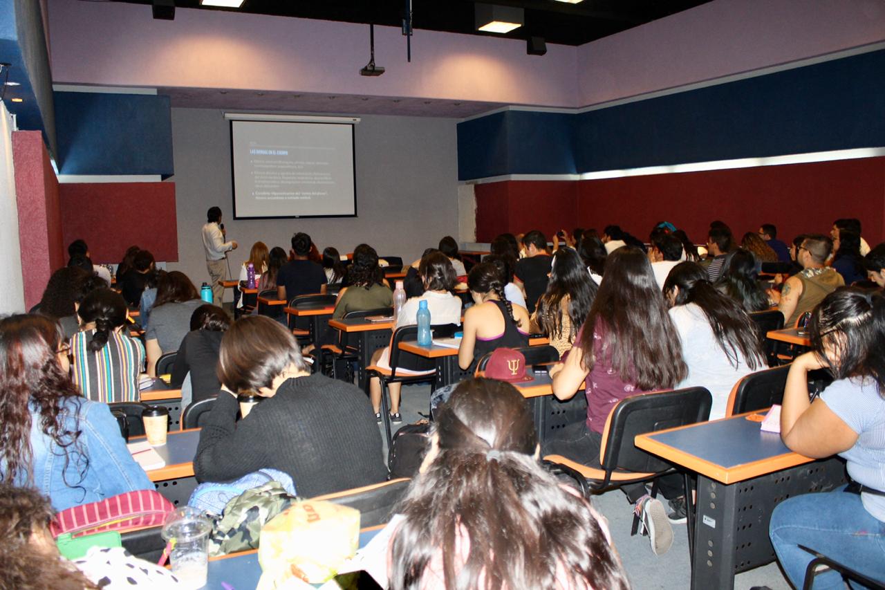 Auditorio lleno de alumnos y docentes, toma desde atras