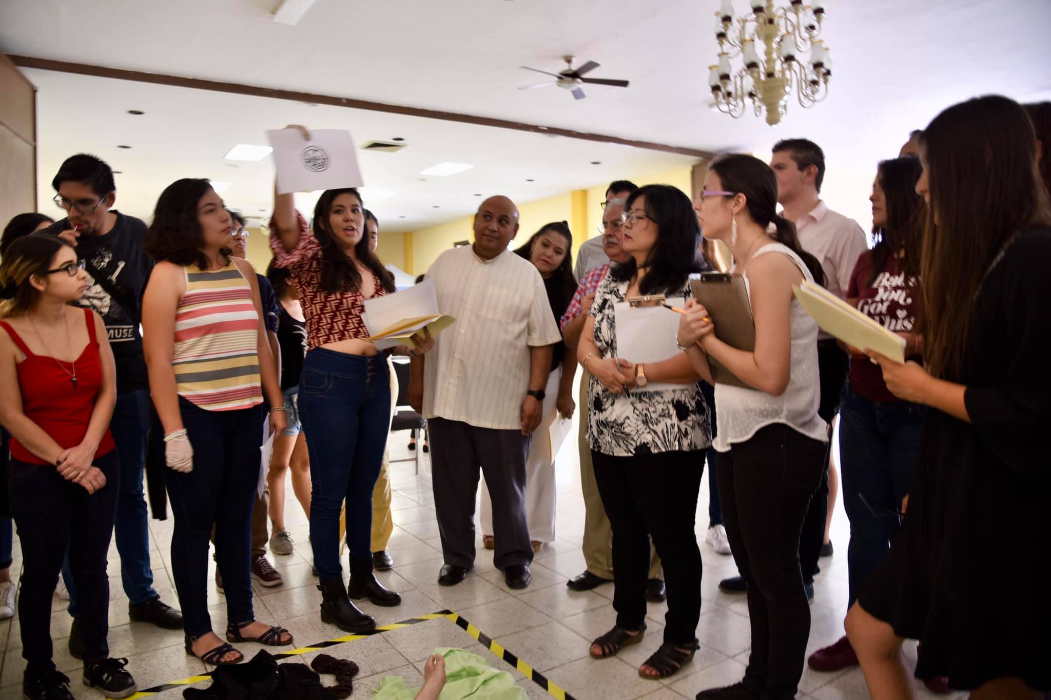 Jueces y equipo docente de apoyo observando otro montaje de escena de crimen