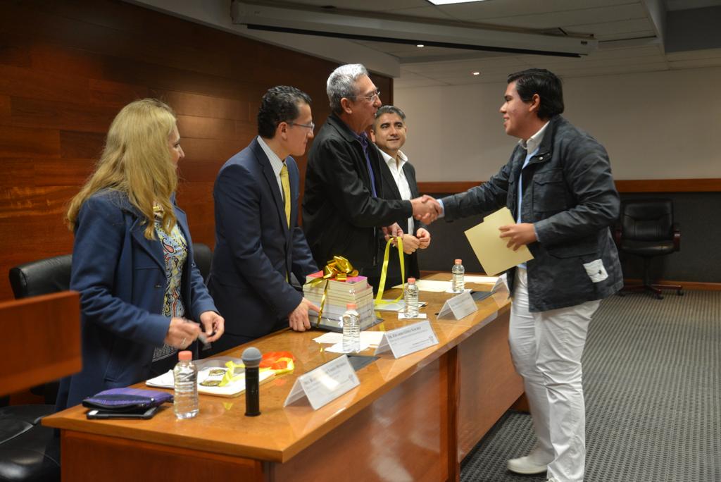 Jurado galardonando a estudiante 