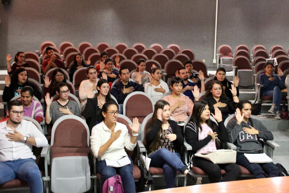 Alumnos desde sus butacas haciendo señas que les enseñó el profesor