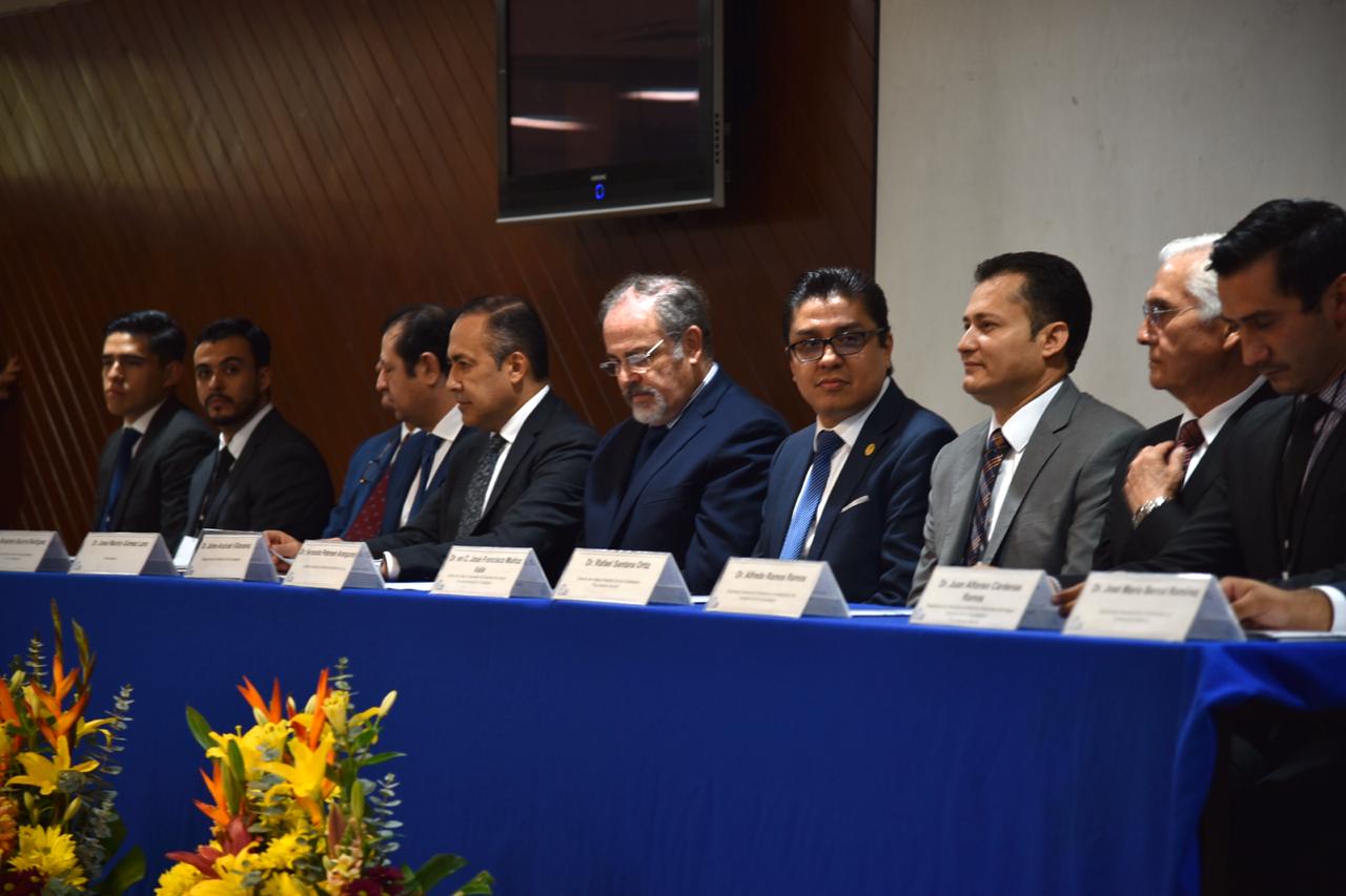 Rector del CUCS sentado al lado del secretario de salud en la mesa del presídium