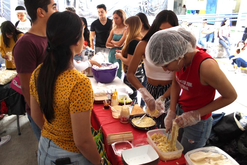 Alumnos preparando alimentos en stand
