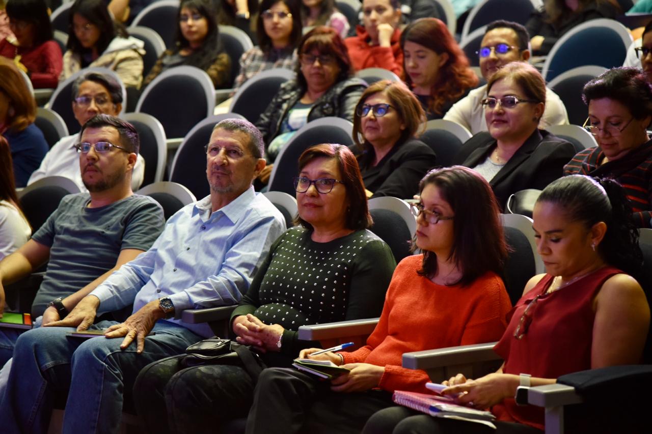 Alumnos de posgrado sentados y atentos a los mensajes