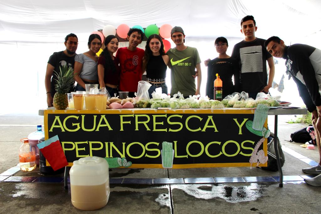 Alumnos atendiendo stand de pepinos