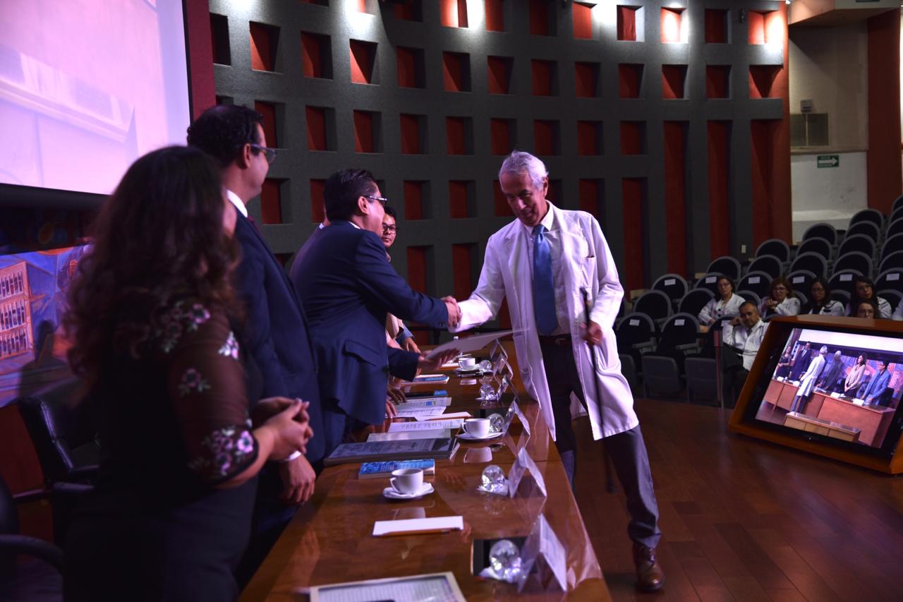 Rector entregando reconocimiento a médico