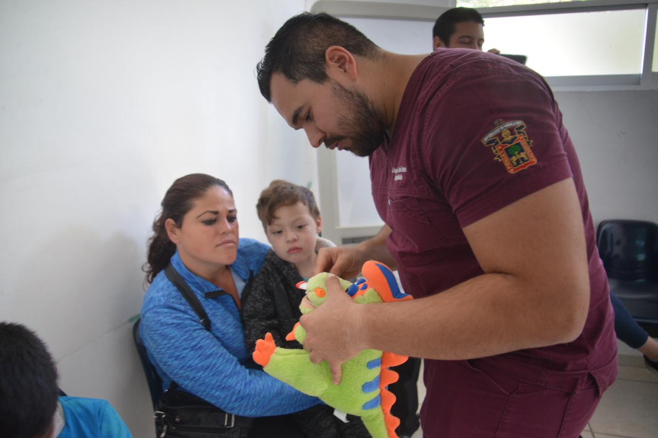 Alumno de especialidad capacitando a mamás en técnicas de cepillado