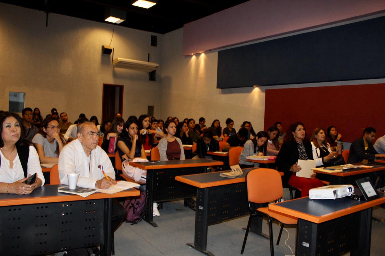 Auditorio lleno de alumno y docentes, toma de frente