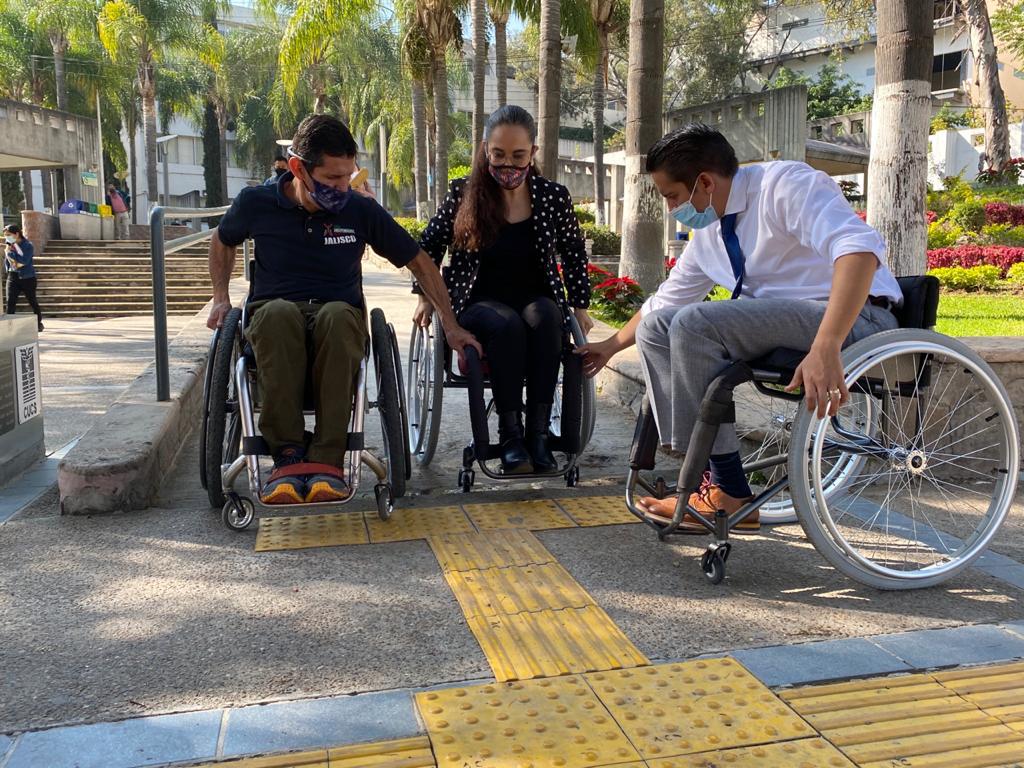 Académicos de CUCS sobre silla de ruedas en un pasillo del Centro