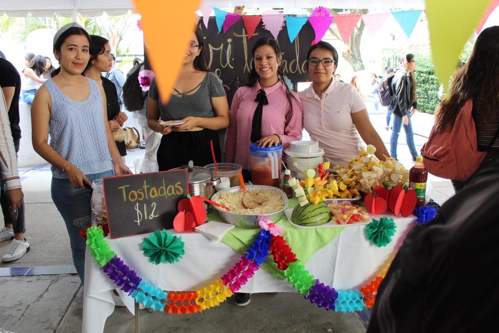 Alumnos atendiendo stand de elotes