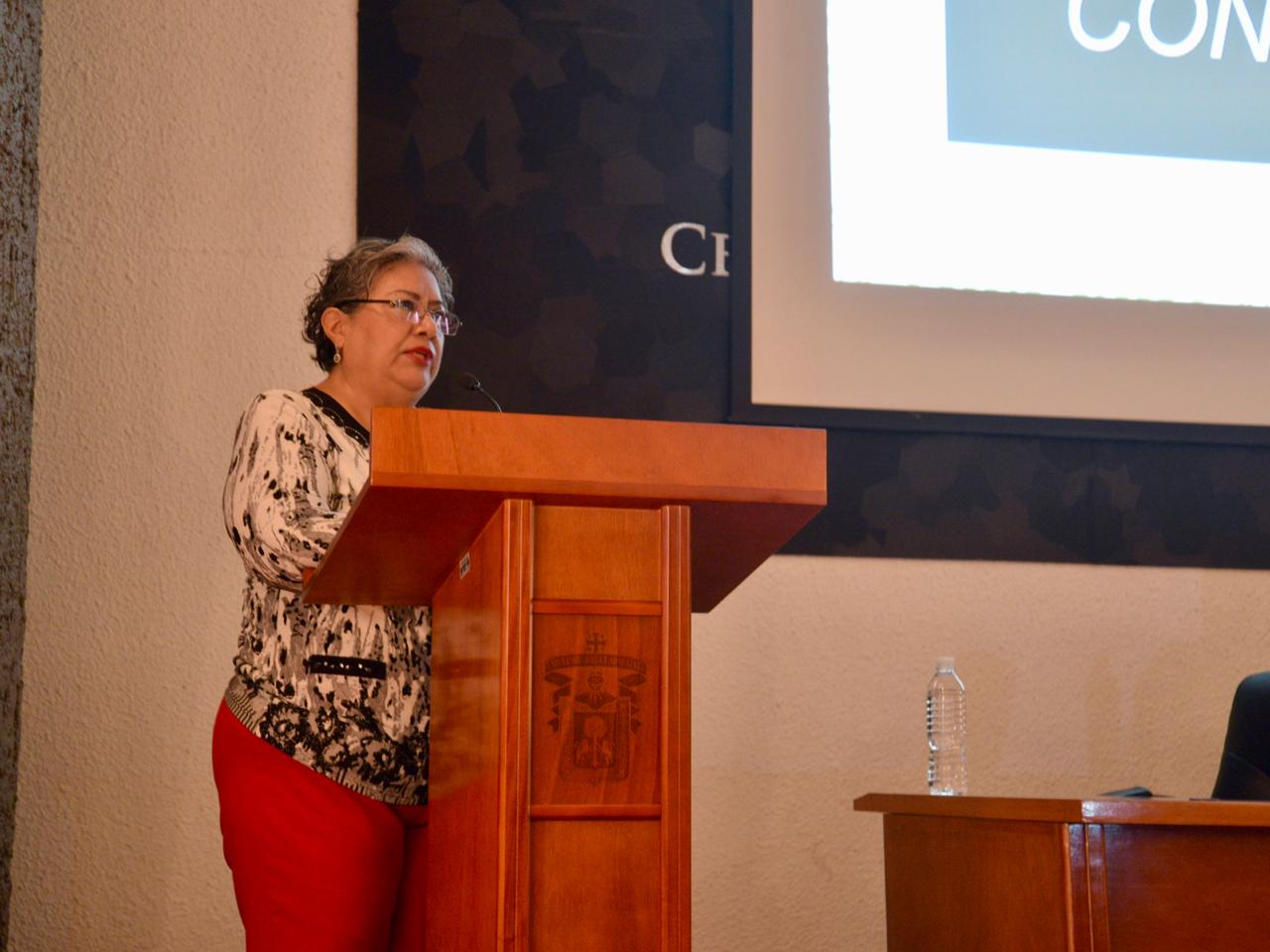 Dra. Getzabel Gallardo impartiendo conferencia en el podio