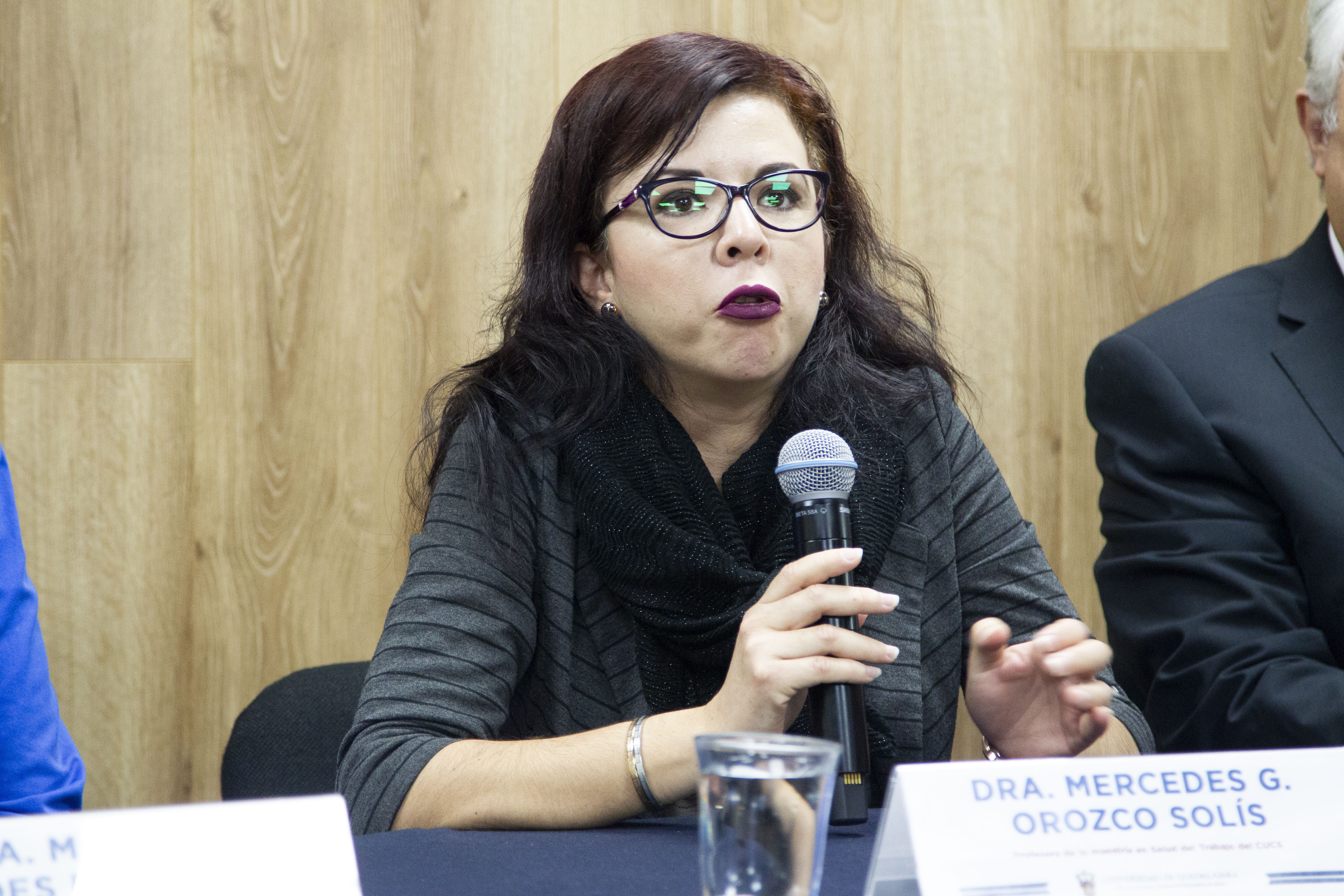 Profesora de la Maestría de Salud en el Trabajo al micrófono