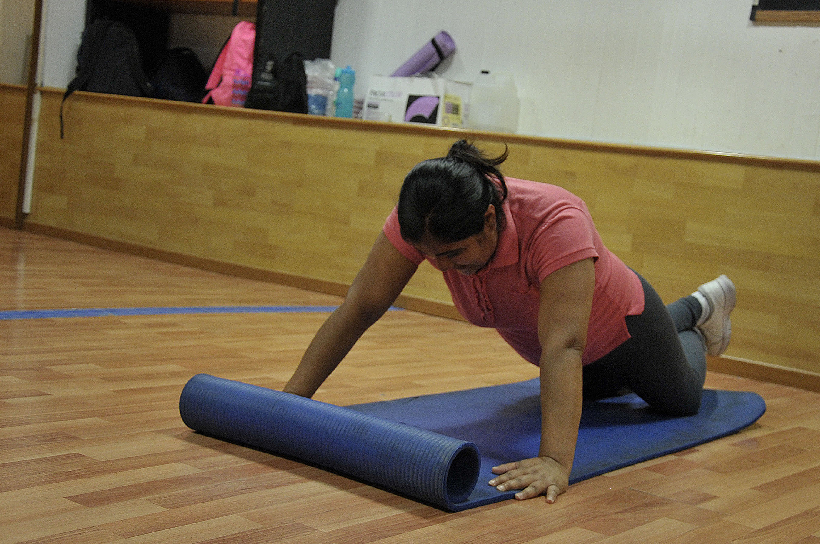 Estudiante sobre un tapete ejecutando una postura de yoga