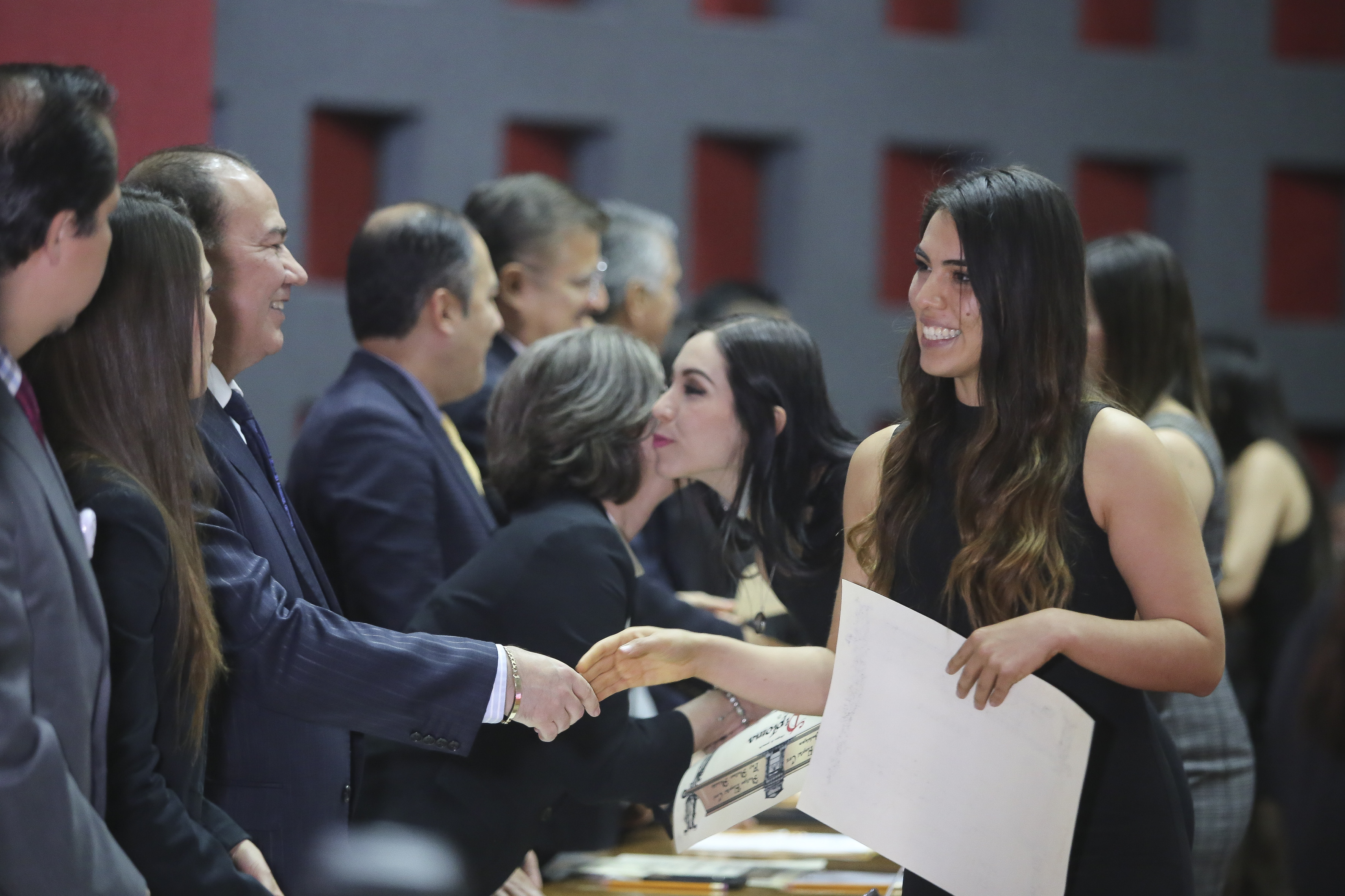 Alumnas graduadas recibiendo su diploma en el presídium