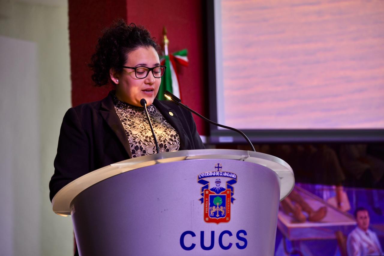 Madrina ofreciendo mensaje a graduados en el pódium