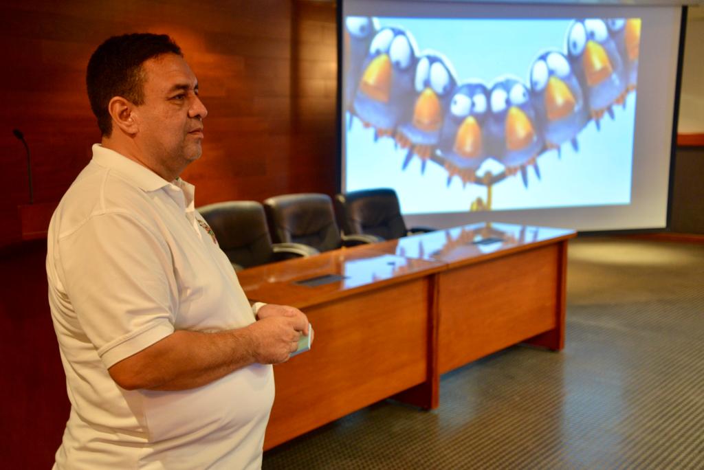 Ponente Curso Acoso Escolar y Bullying, al fondo la pantalla donde se ve un video