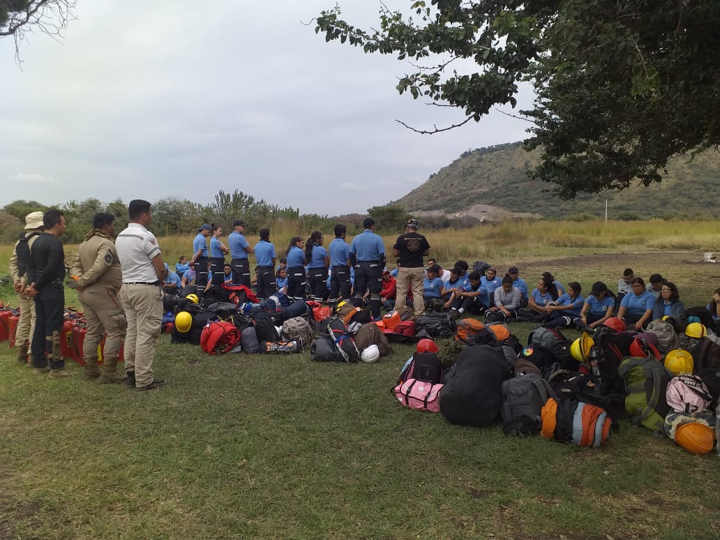 Alumnos recibiendo instrucciones en el campo de prácticas