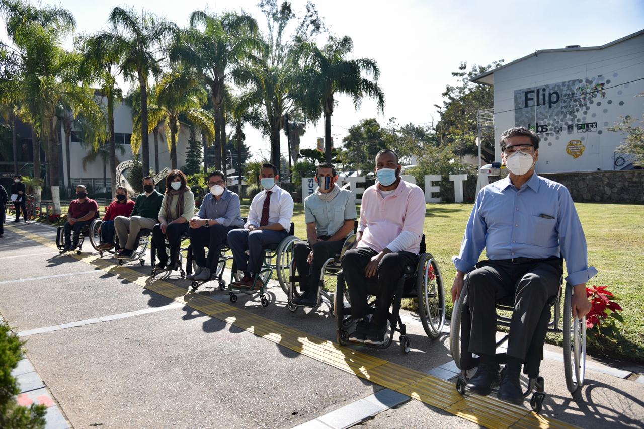 Funcionarios y directivos sentados en silla de ruedas posando para la foto