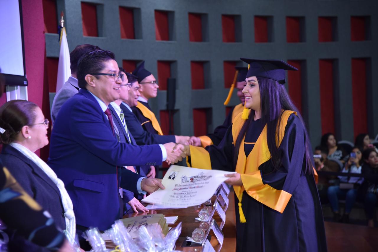 Rector entregando constancia a graduada