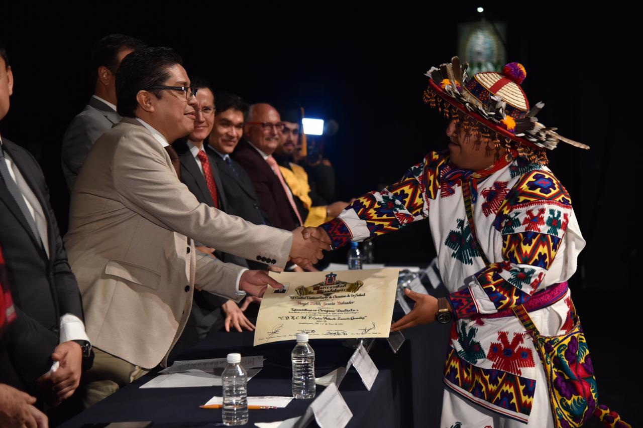 Rector entregando reconocimiento a graduado wixárica