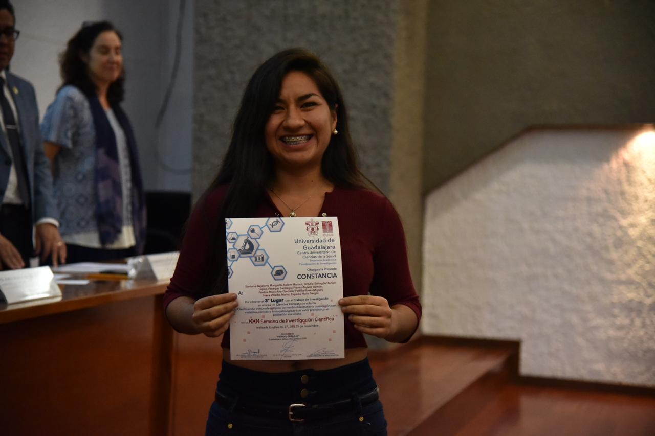 Alumna ganadora exhibiendo su reconocimiento