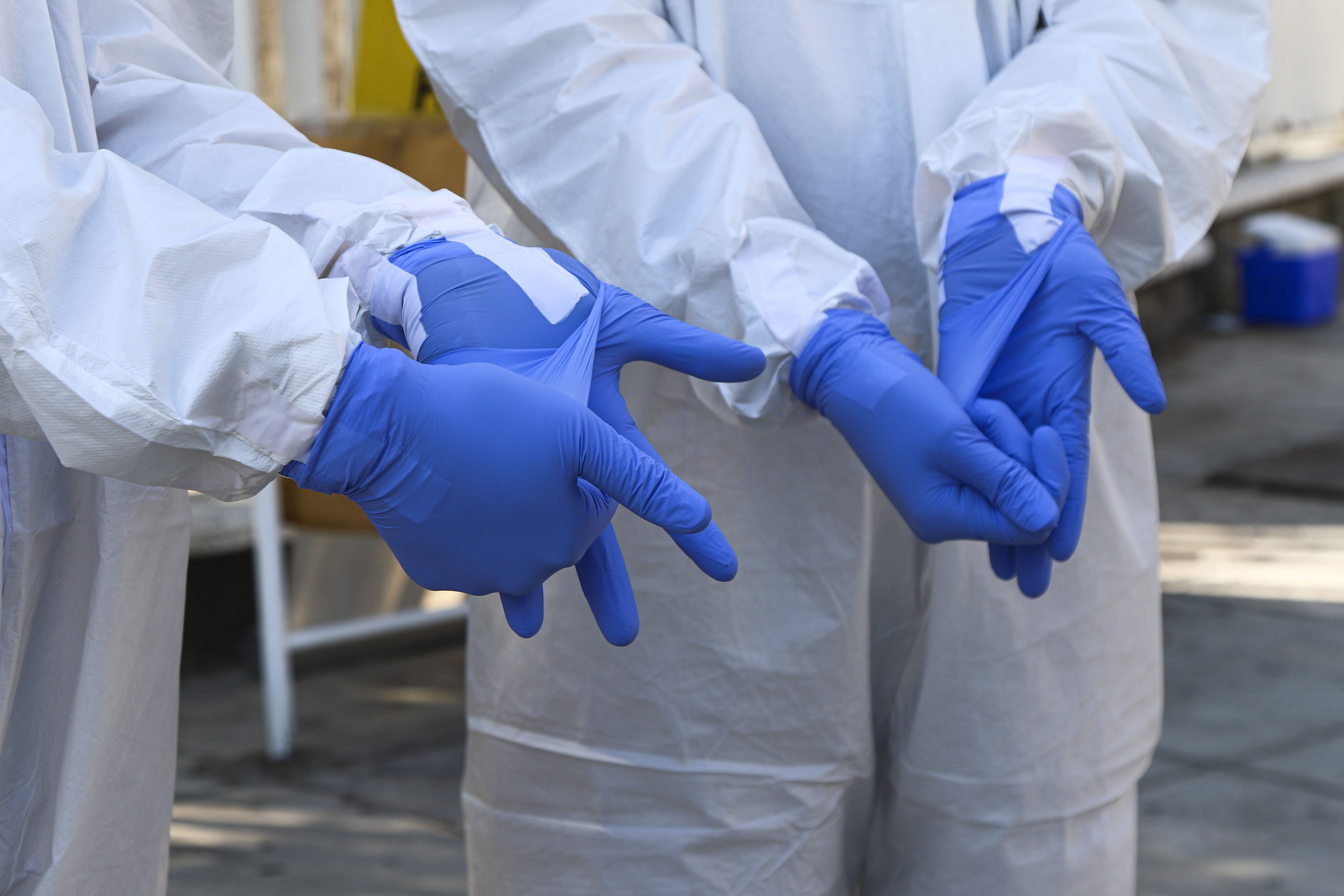 Manos de brigadistas con dobles guantes azules