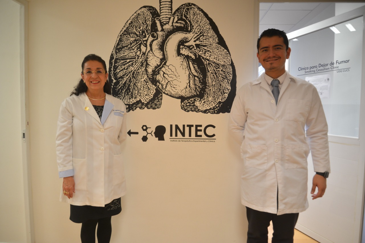 Dra. Esperanza Martínez y Dr. Luis Gaytán. Atrás letrero de INTEC en la pared