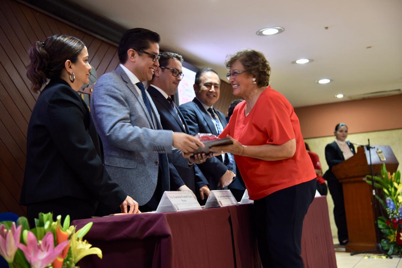Dra. Cuquita recibiendo reconocimiento de manos del rector del CUCS