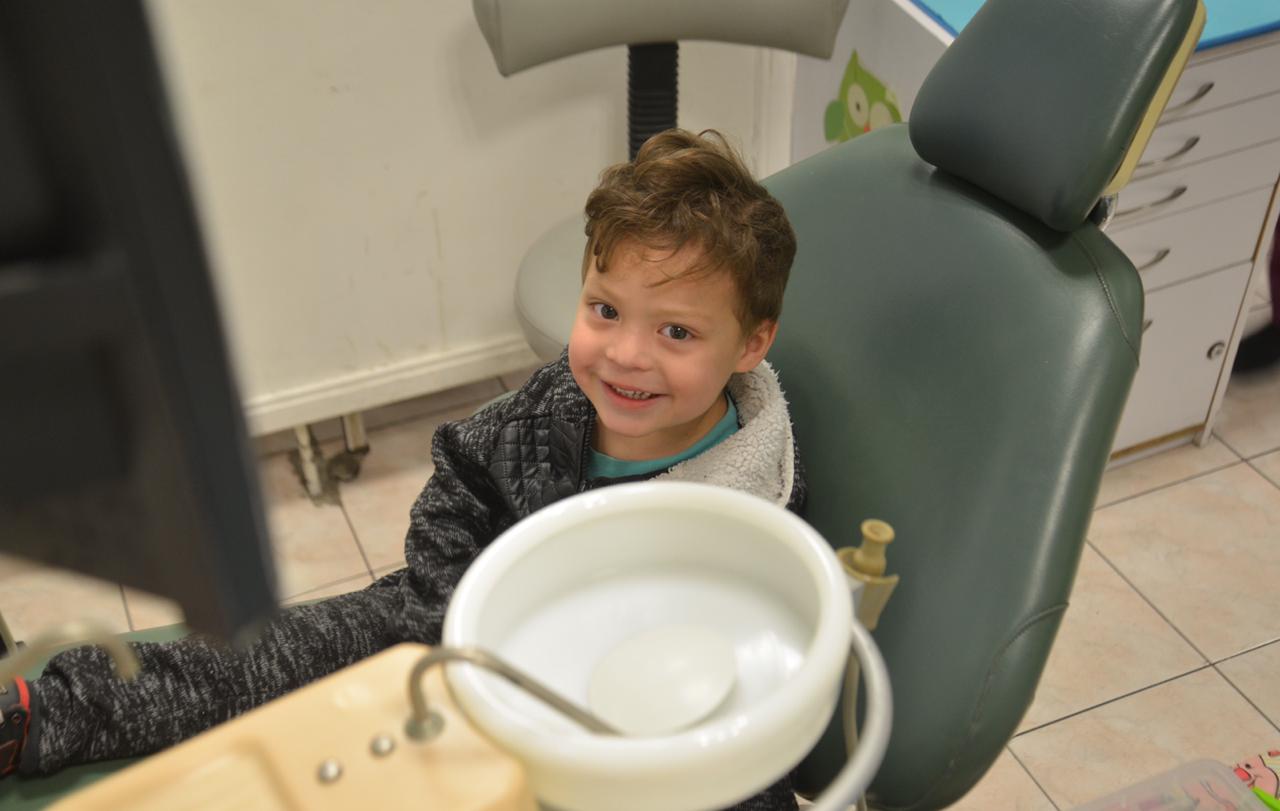 Niño de 2 años sonriendo en sillón odontológico