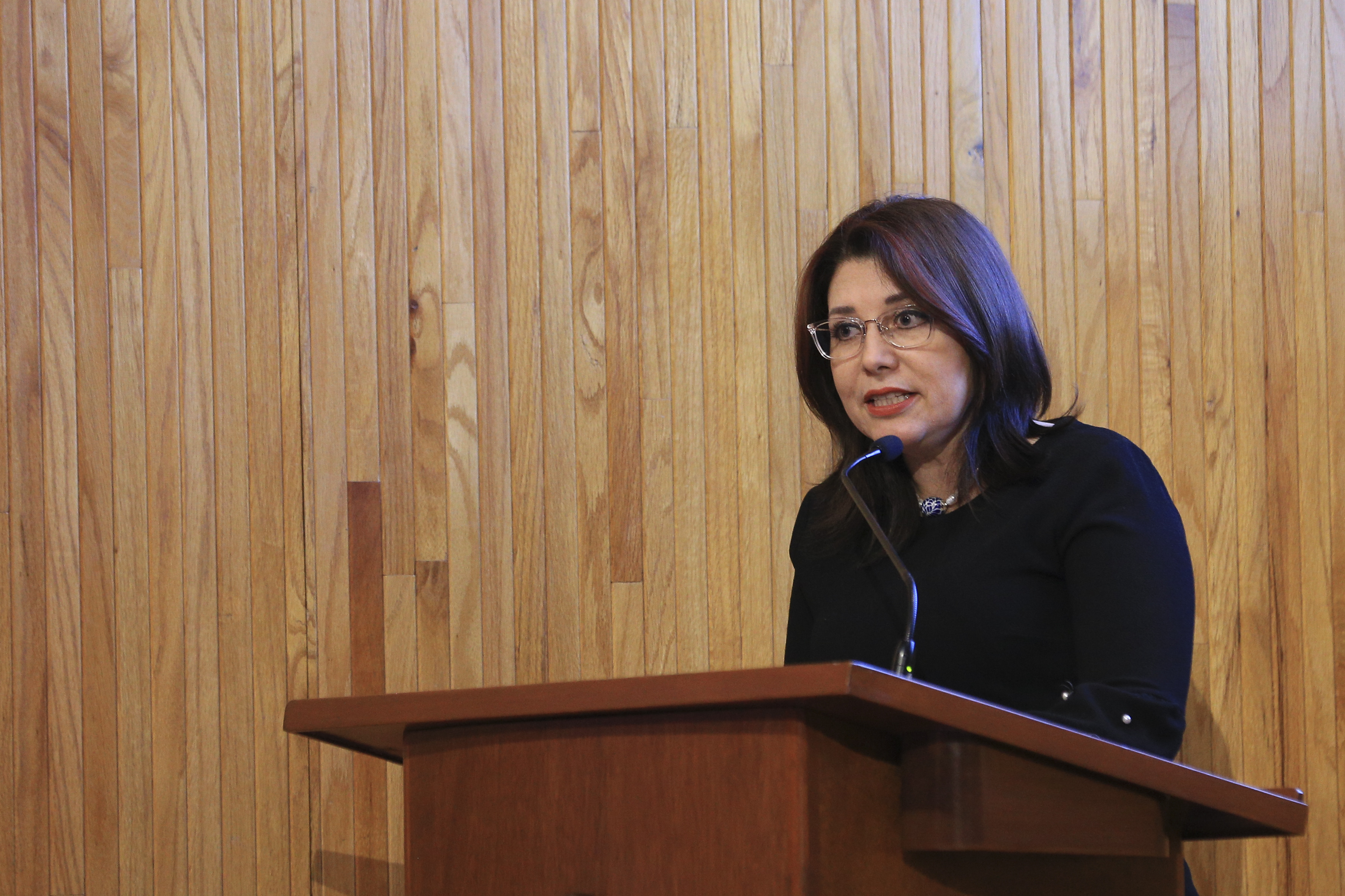 Vicerrectora ejecutiva dando mensaje a estudiantes reconocidos en el Paraninfo