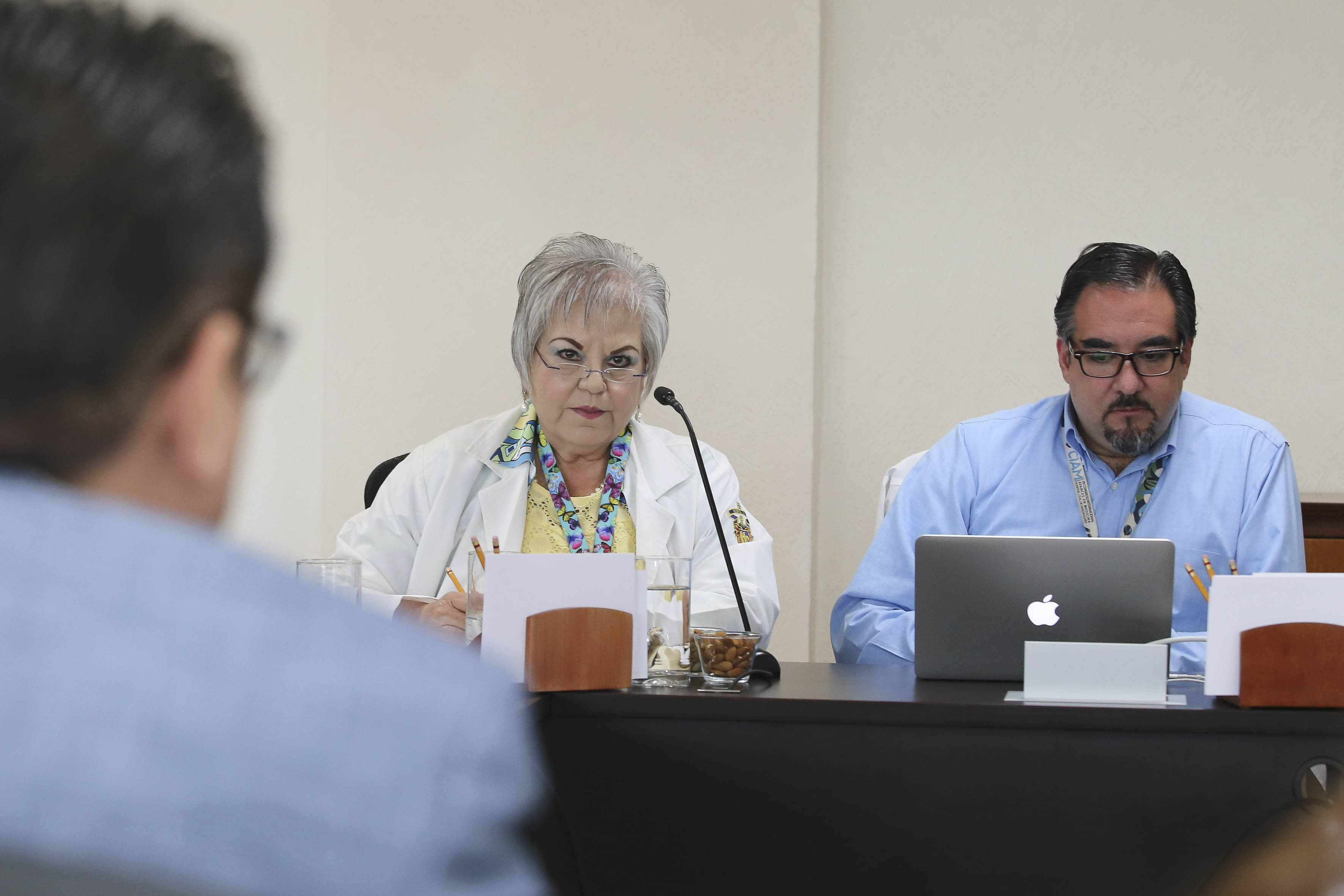 Rector del CUCS de espaldas, al fondo dos investigadores del CUCS