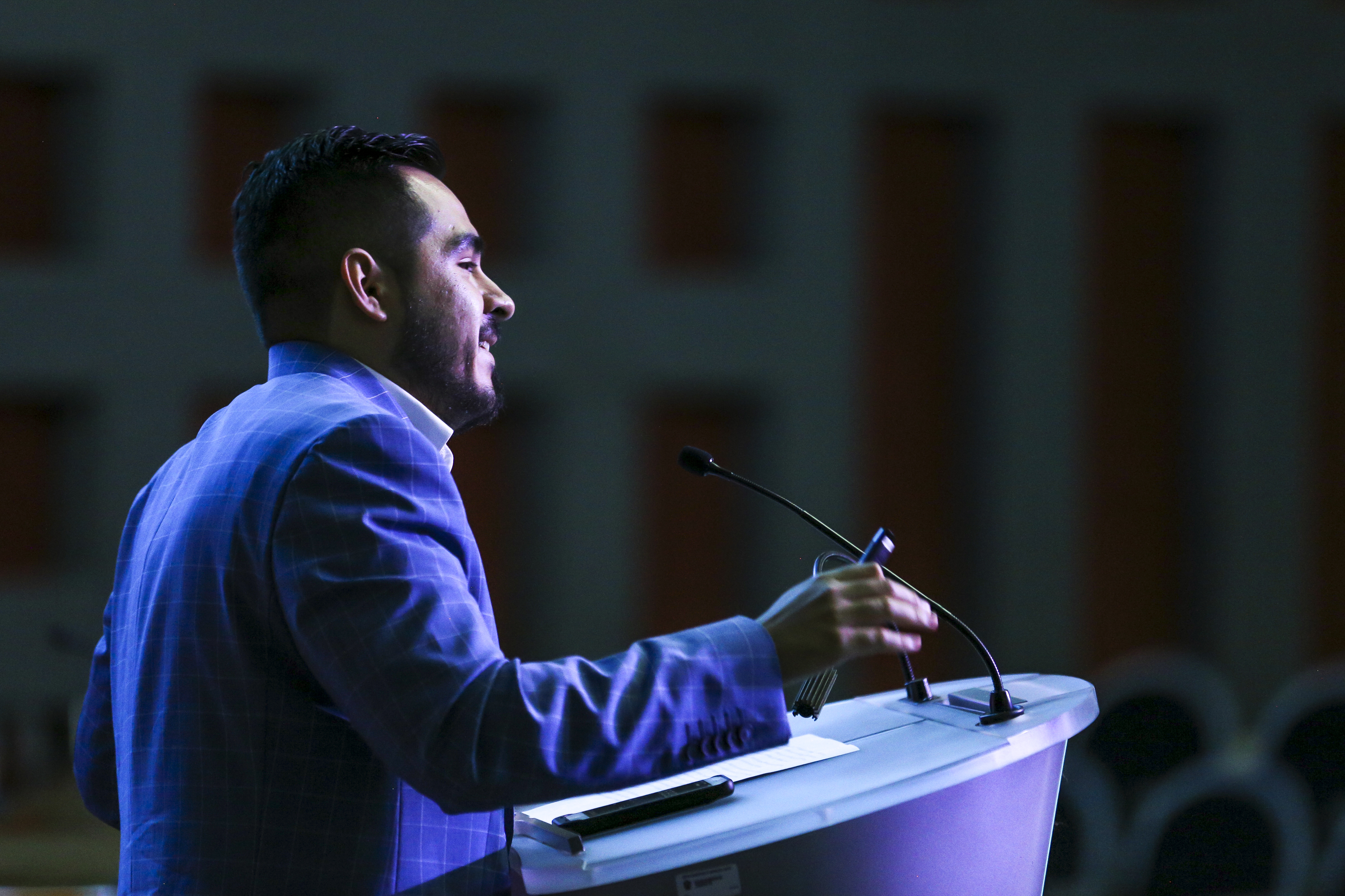 Conferencista en podium, toma de perfil