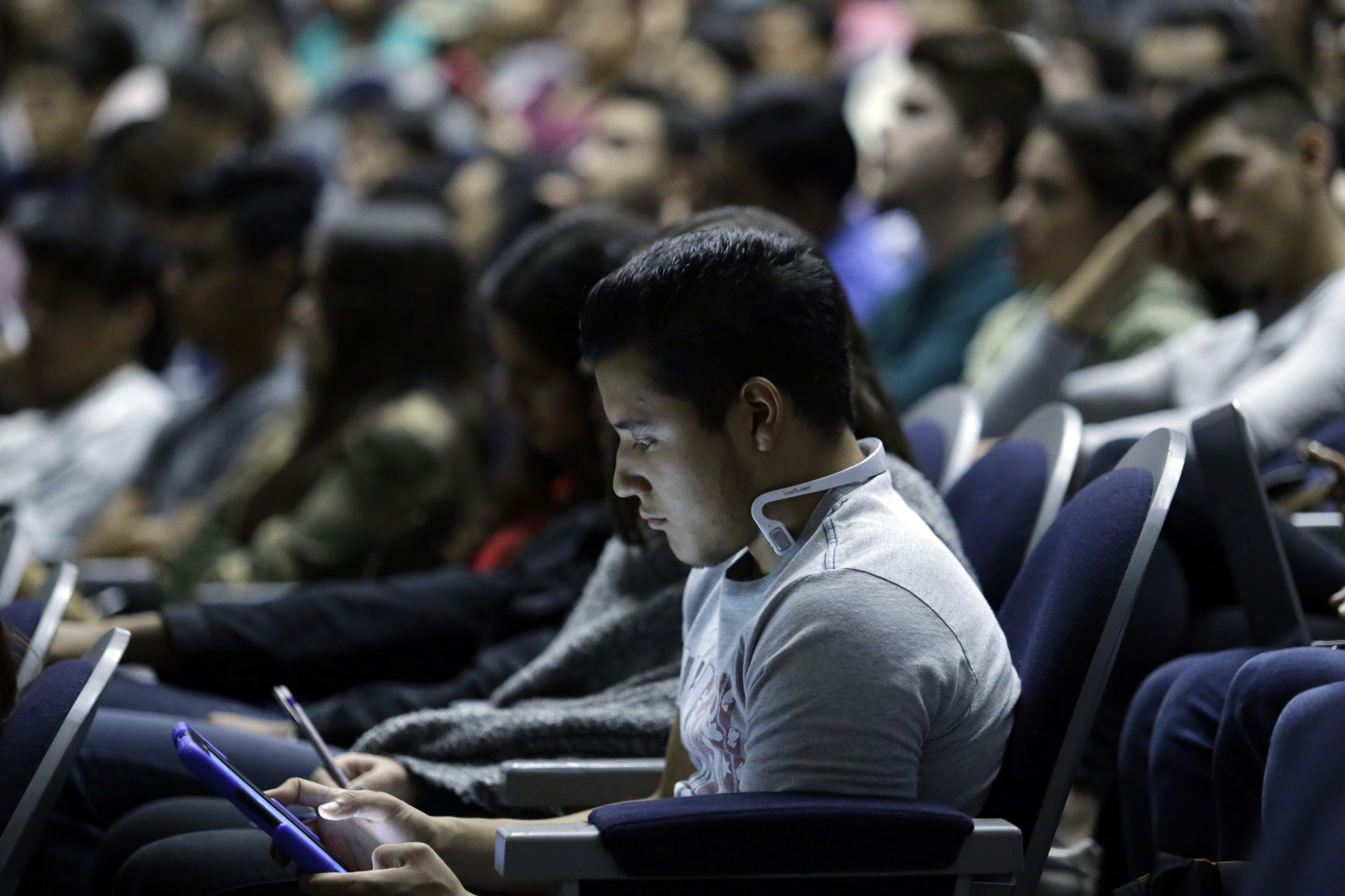 Alumno haciendo consulta en su tablet durante la conferencia